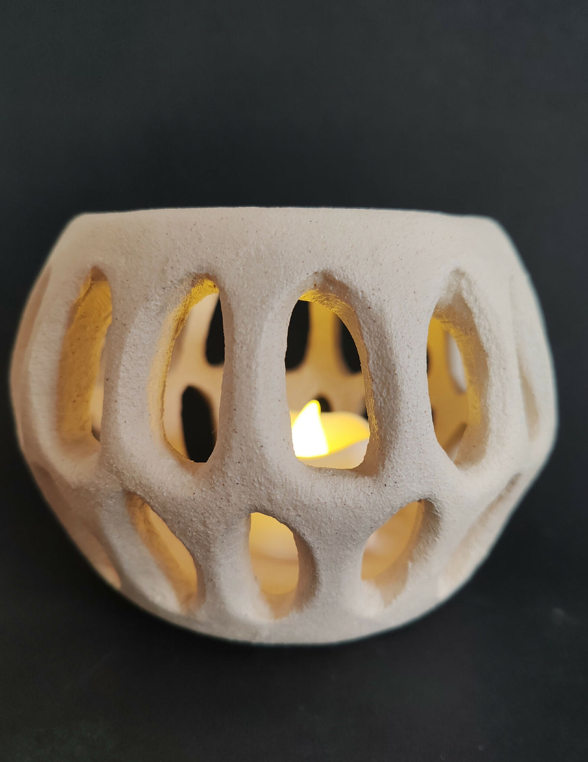 Sculpture SOUFFLE BLANC II ajourée, éclairage jaune à travers les trous