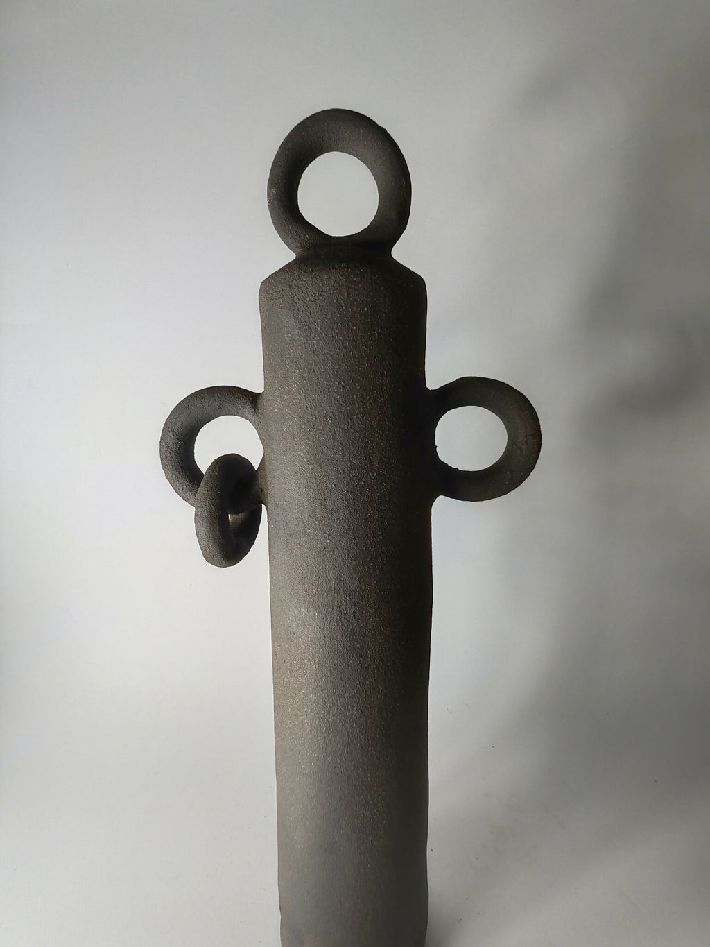 Sculpture totem noir debout avec anneau supérieur et trois petites anses décoratives