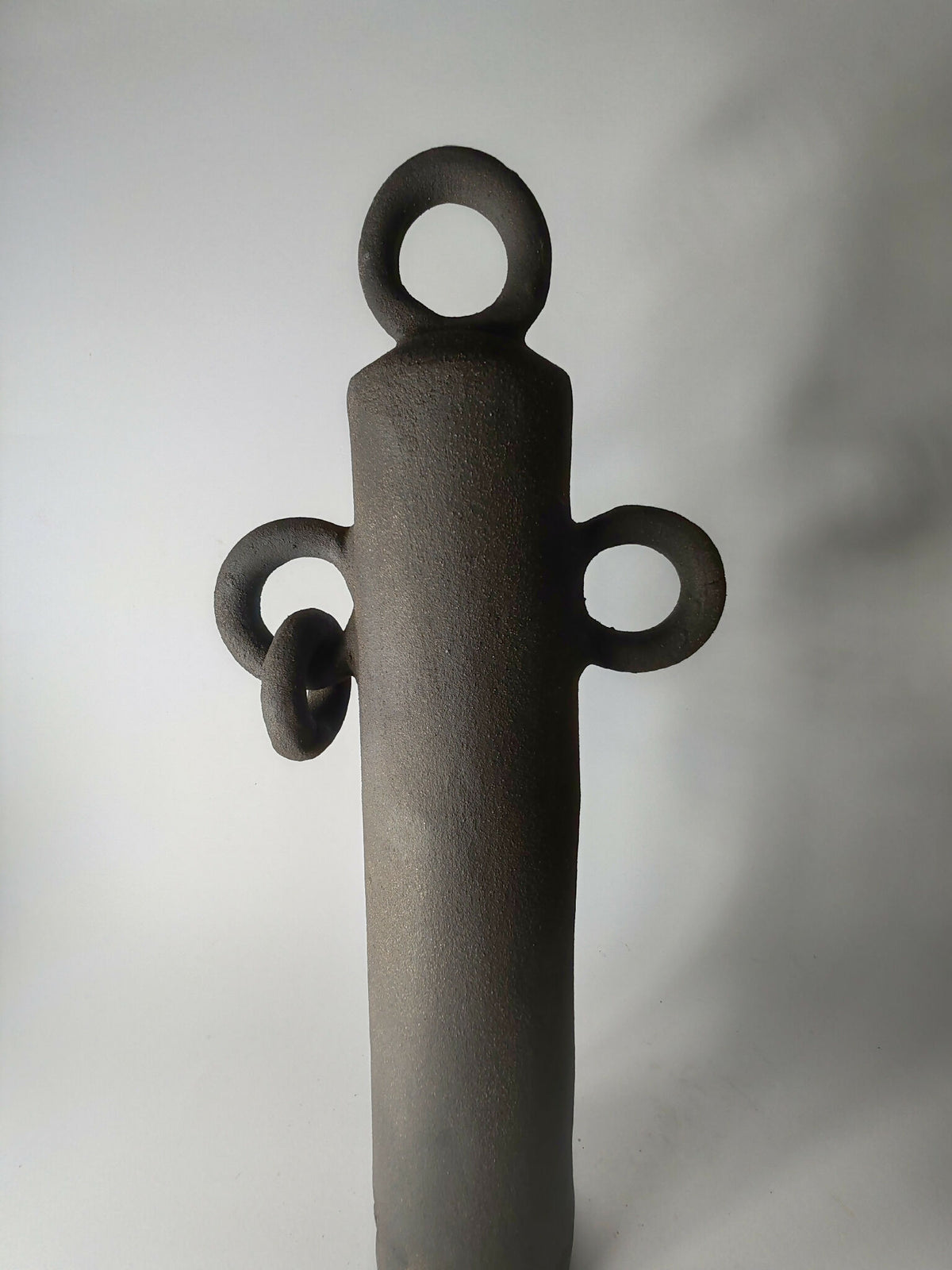Sculpture totem noir debout avec anneau supérieur et trois petites anses décoratives
