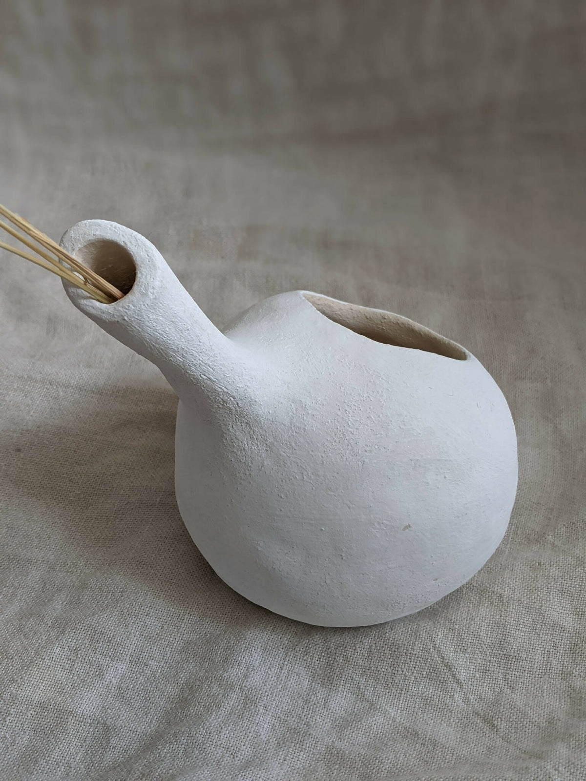 Vase sculpture bulbe blanc, ouverture ovale avec tiges sèches