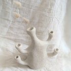 Vase corail beige en céramique avec plusieurs ouvertures, tiges de fleurs et petits plumets