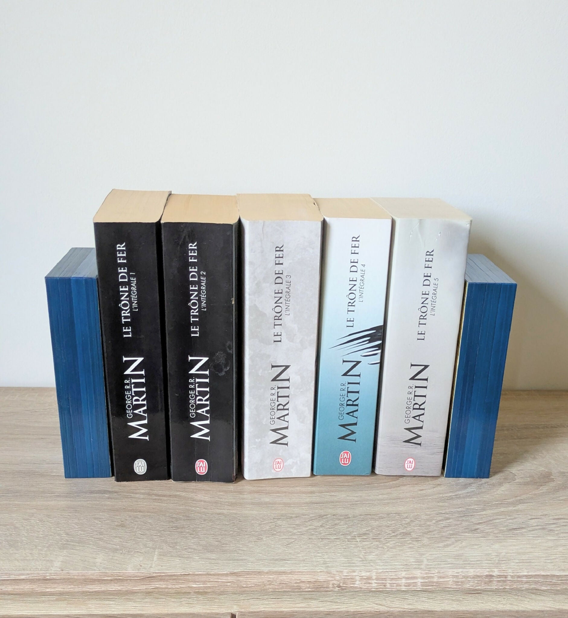 Serre-livres duo bleus et clairs en marqueterie de paille, disposés avec des livres