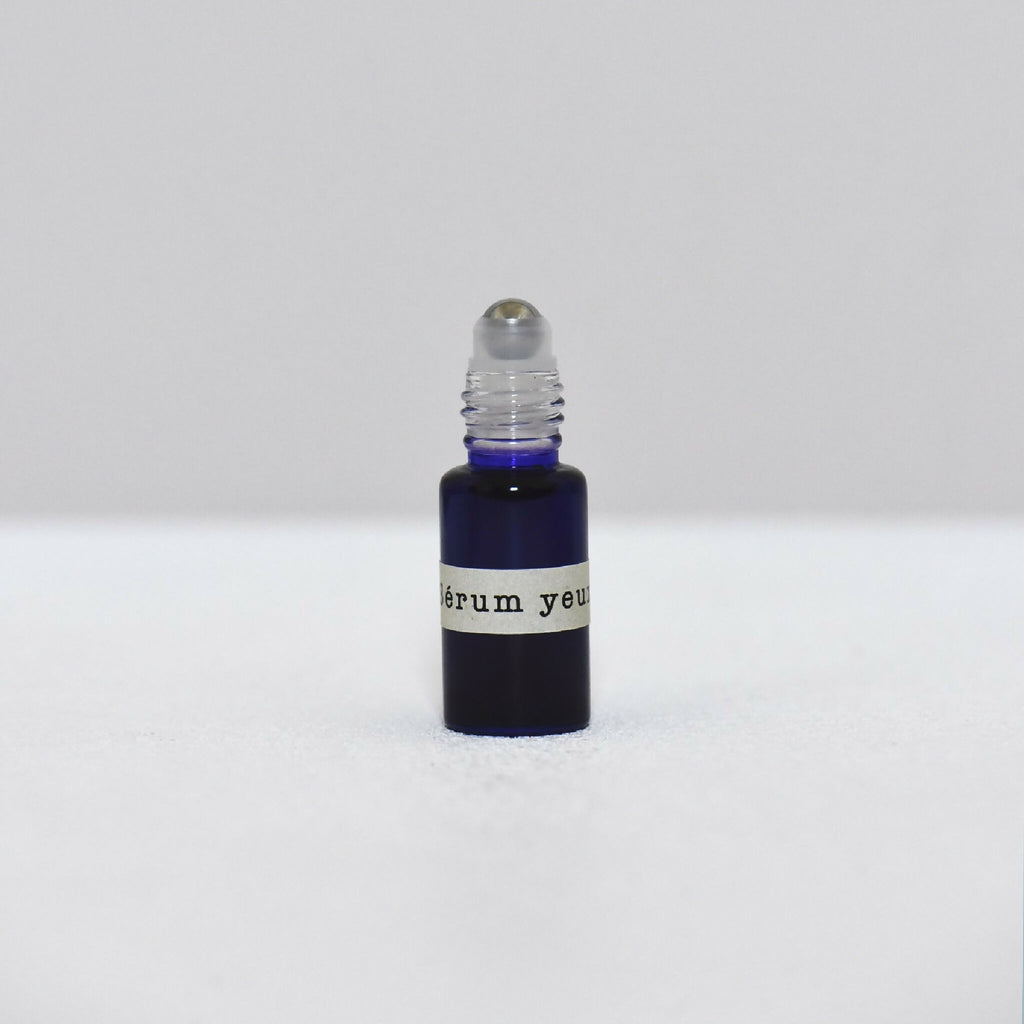 Flacon de sérum pour les yeux avec compte-gouttes et bouchon noir sur base bleu