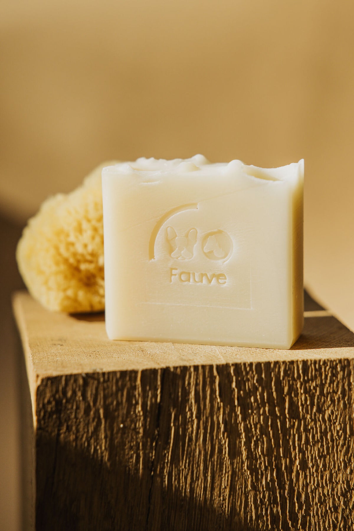 Savon shampooing solide Fauve ivoire, barre avec logo posée sur bois