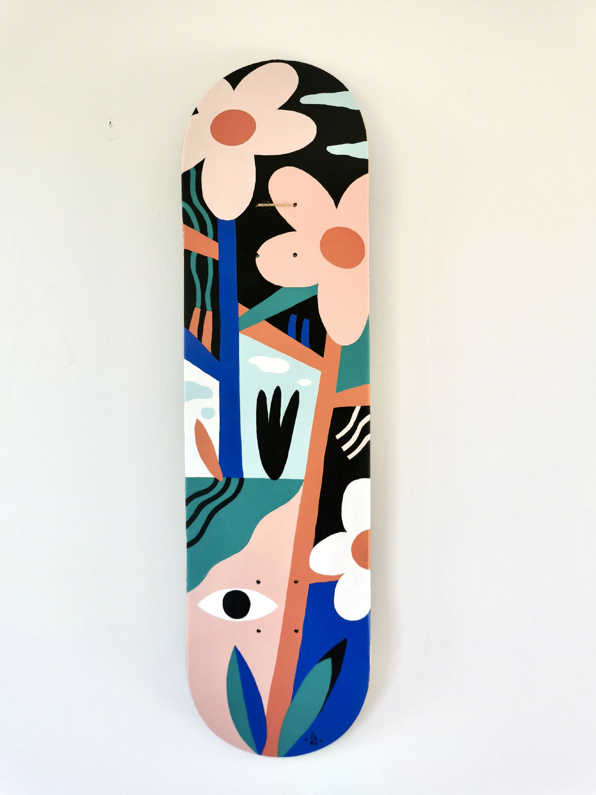 Skateboard décoré d’illustrations abstraites aux fleurs et visages, couleurs bleu et noir.