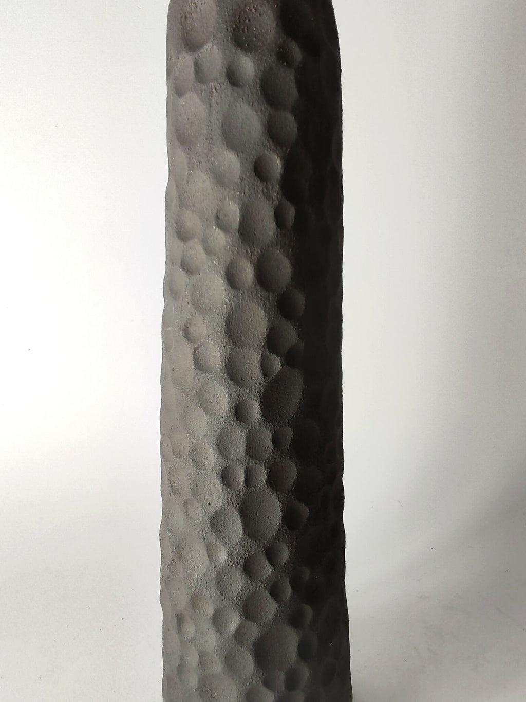 Soliflore sculpté noir à texture en pastilles, vue latérale rapprochée.