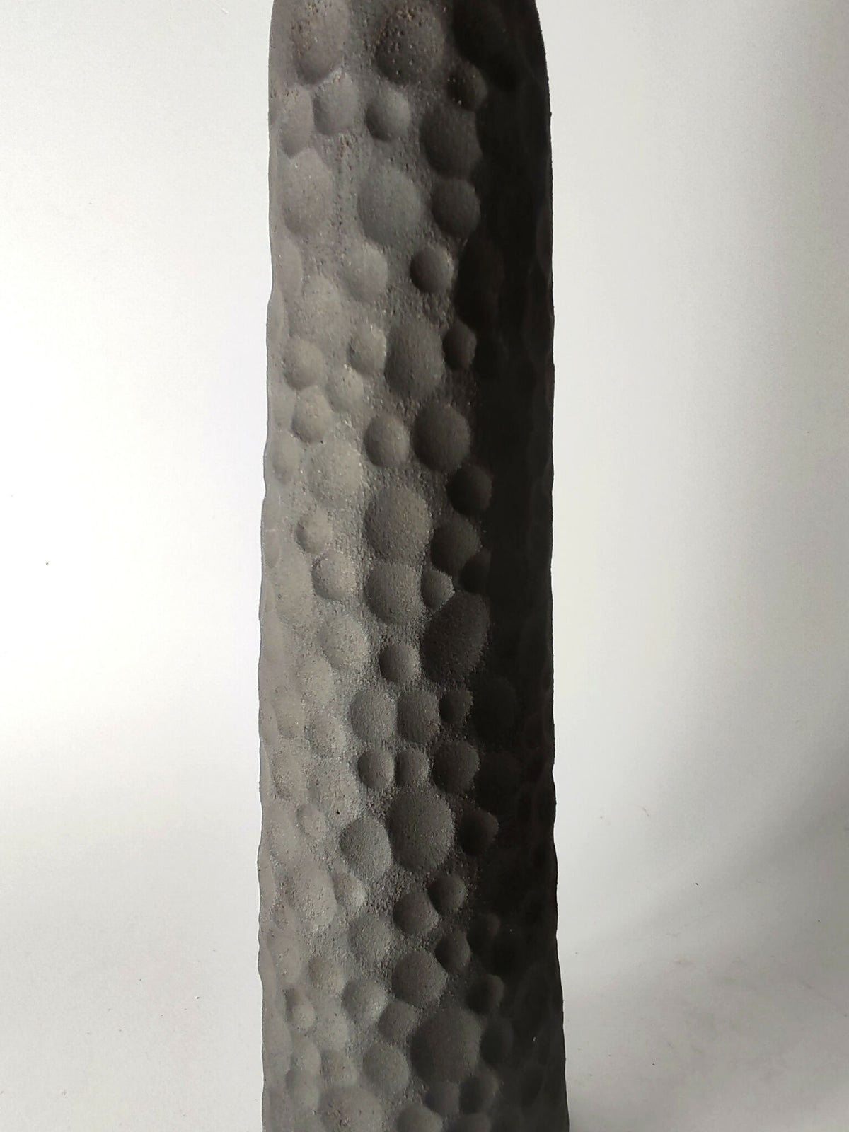 Soliflore sculpté noir à texture en pastilles, vue latérale rapprochée.