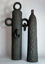 Ensemble de soliflores sculptés noirs : une pièce à anses et une bouteille à relief.