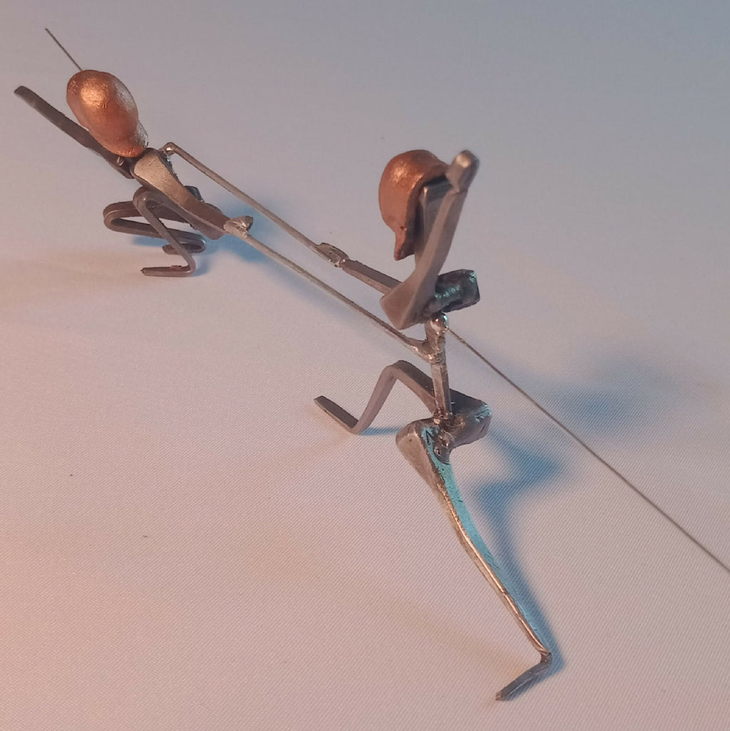 Deux statuettes d’escrimeuses en acier, une en extension haute, une en appui, têtes cuivre.