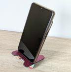 Support de téléphone avec smartphone noir posé, marqueterie rayée bordeaux et turquoise.