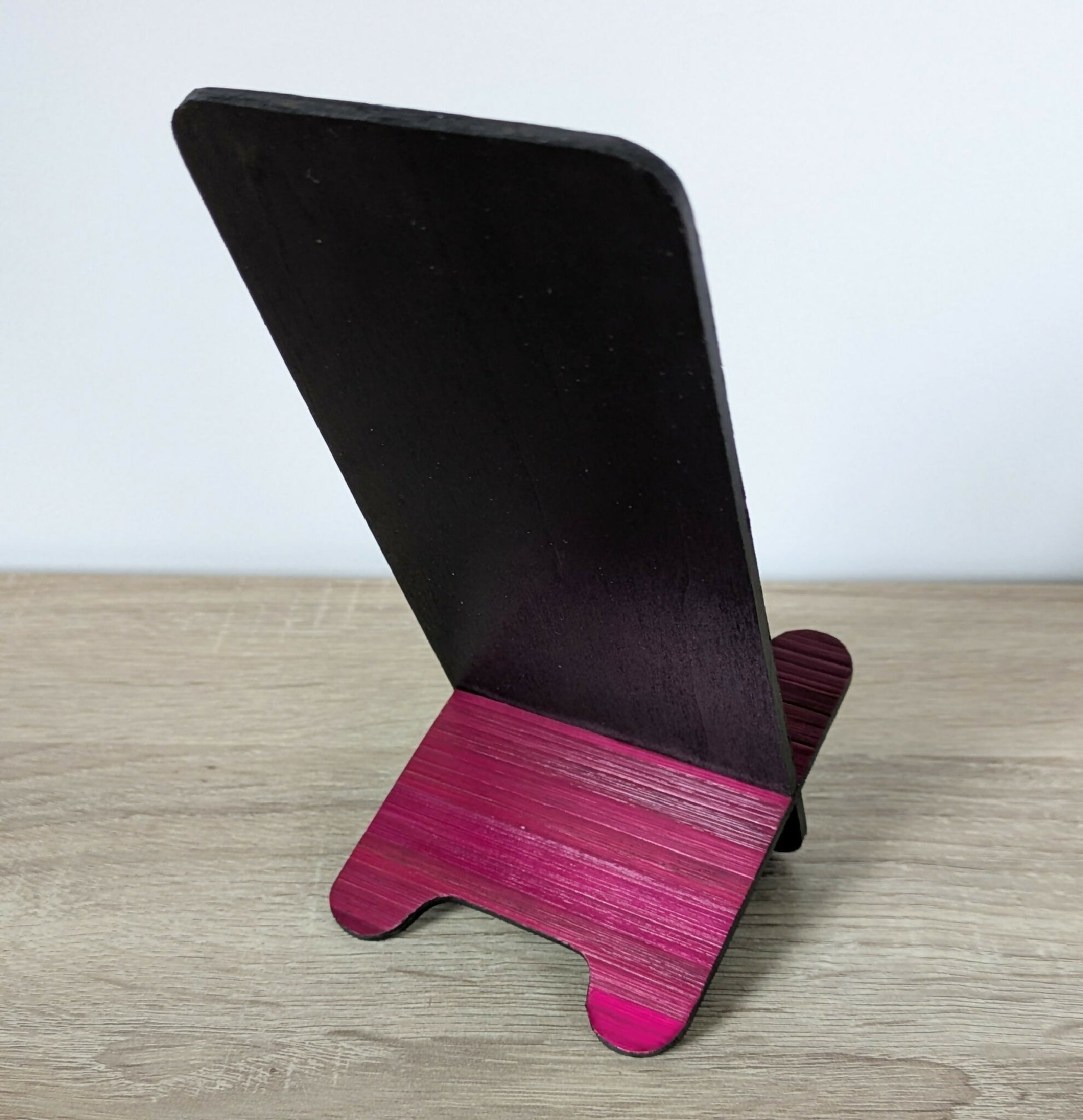 Support de téléphone incliné, panneau noir et base marquetée bordeaux.