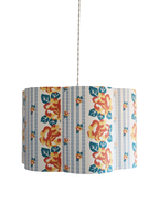 Abat-jour forme fleur en tissu bleu clair, fleurs orange et rayures de chaînettes.