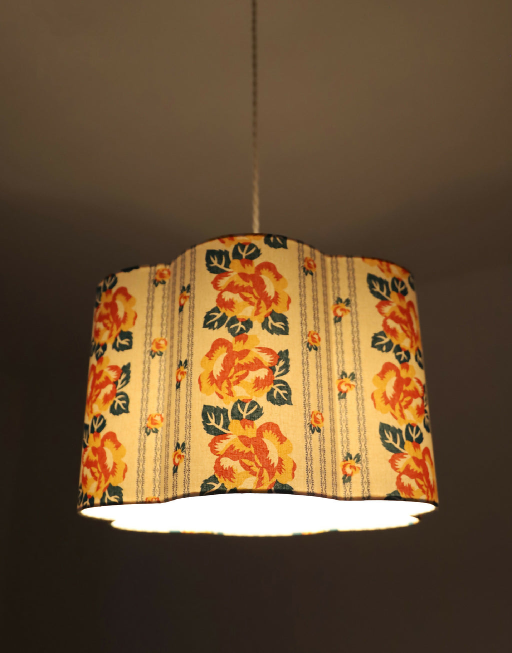 Abat-jour forme fleur en tissu crème à fleurs orange, motif rayé de chaînettes.