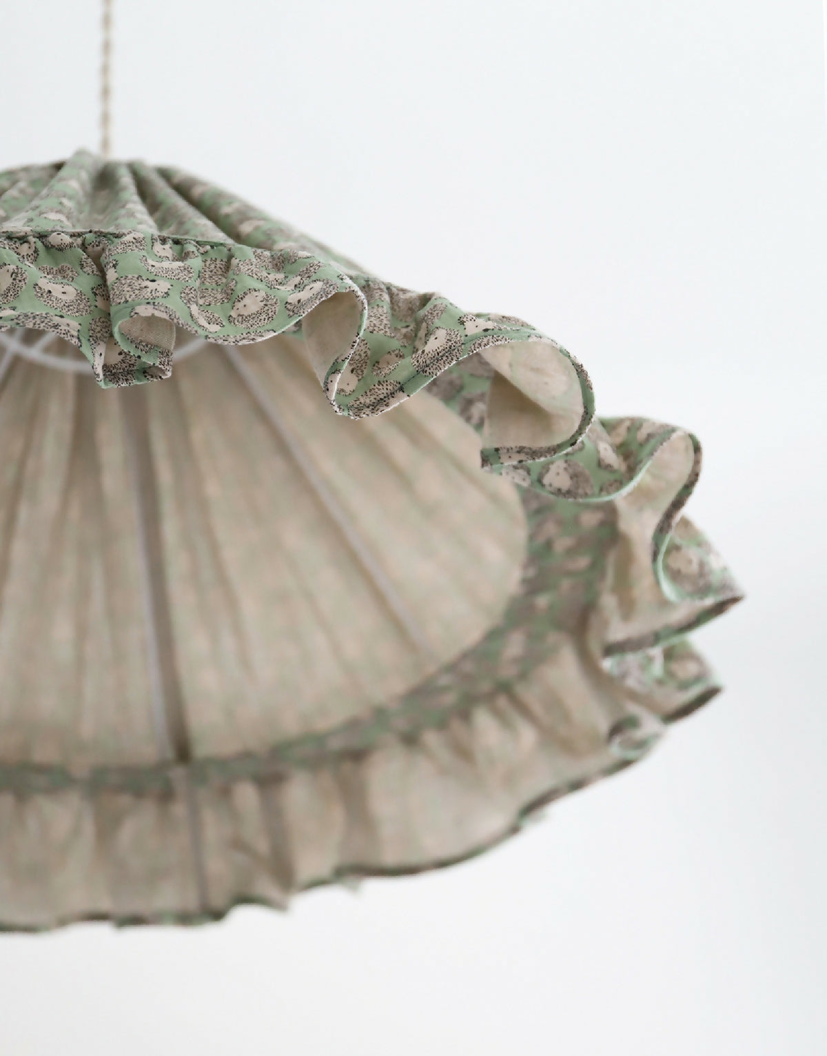 Suspension conique : bord volanté en tissu vert à motifs de petits hérissons