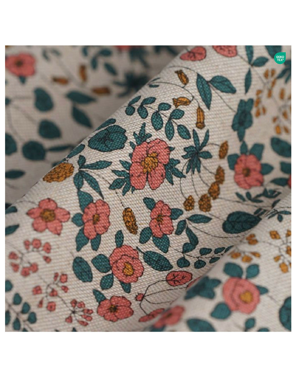 Gros plan tissu floral : fleurs et feuilles multicolores sur fond clair, coutures visibles.
