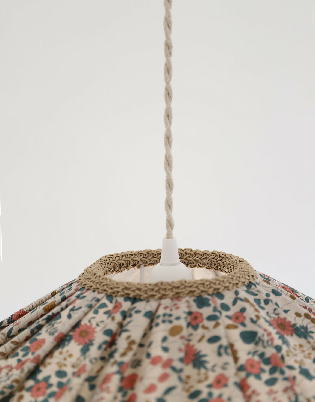 Suspension de l’abat-jour : cordelette en haut et bord festonné en tissu beige.