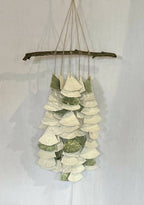 Décoration murale suspendue : barres en bois et clochettes en papier blanc et vert