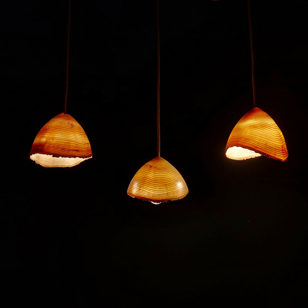 Suspension en frêne : trois abat-jours demi-lune en bois, lumière chaude
