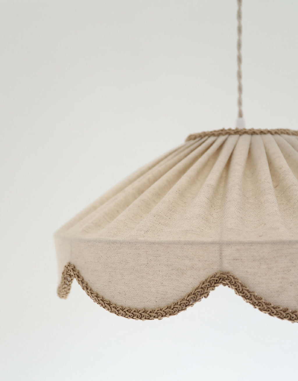Abat-jour en tissu beige avec bordure festonnée en tresse brune