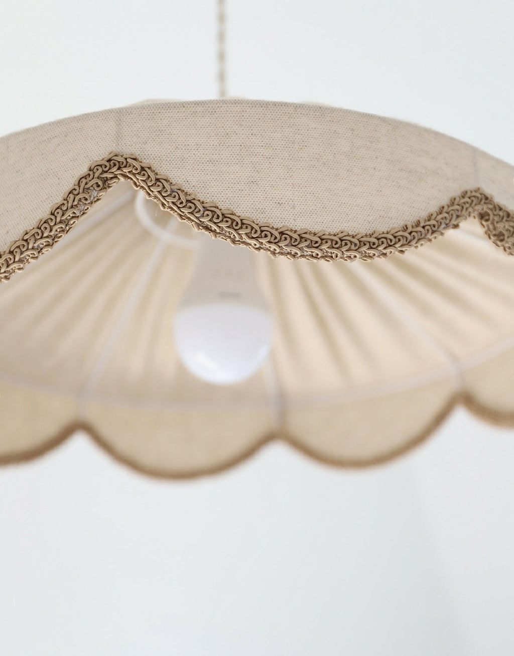 Abat-jour beige festonné avec éclairage central, bordure en tresse brune