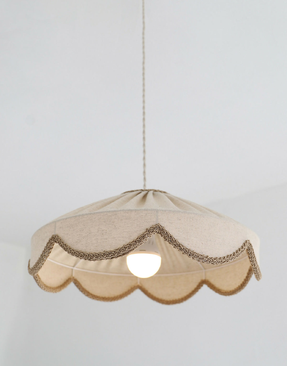 Suspension abat-jour beige festonné, tresse brune et lumière centrale