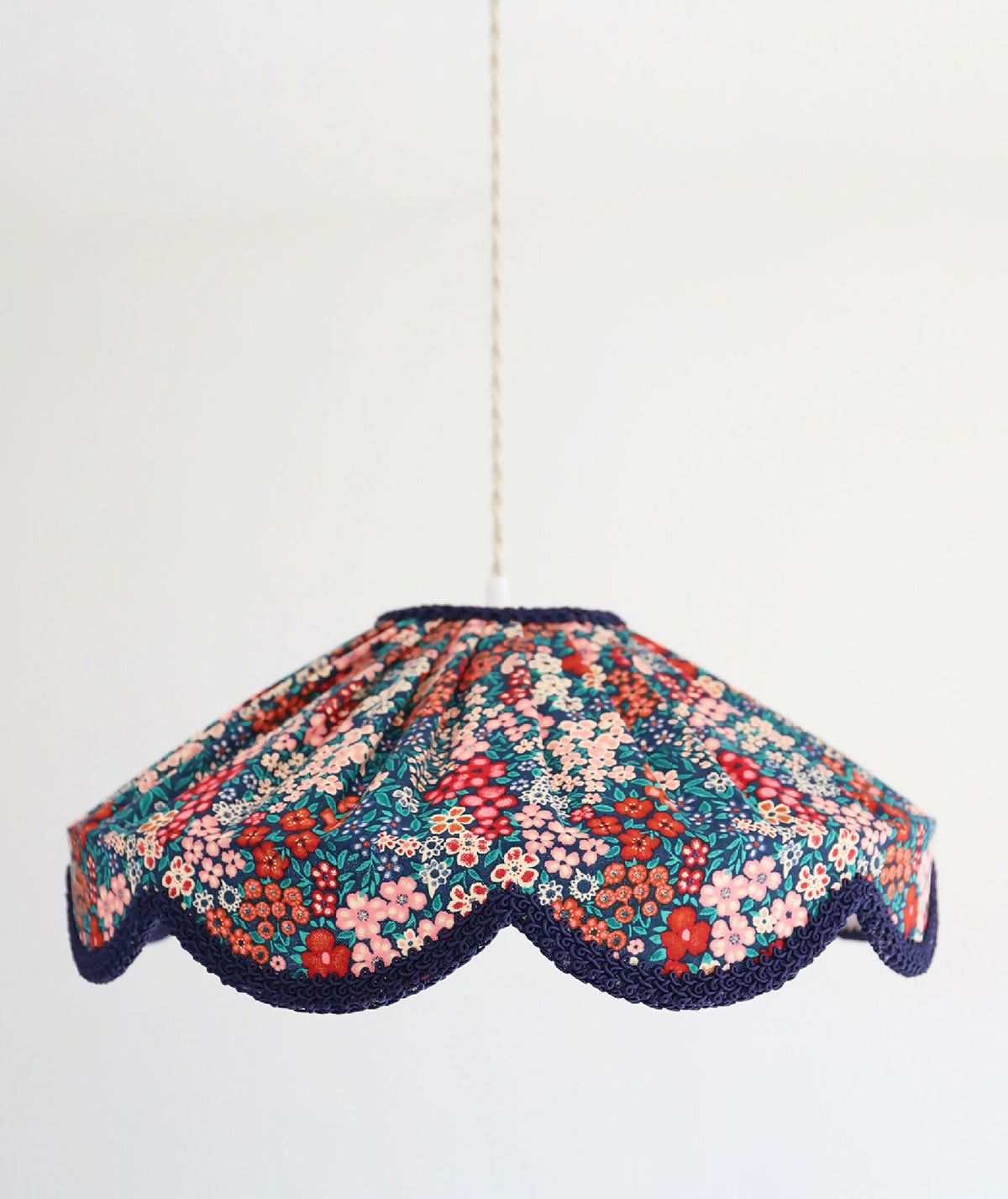 Suspension abat-jour en tissu floral mille fleurs, contours festonnés bleu marine.