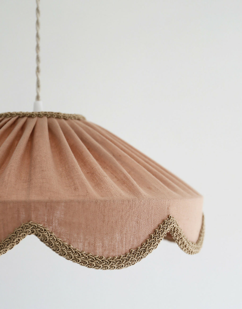 Abat-jour suspendu en lin beige rosé, vue de côté avec festons et finition dorée