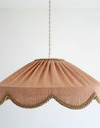 Abat-jour suspendu en lin beige rosé, forme conique froncée et bord festonné doré