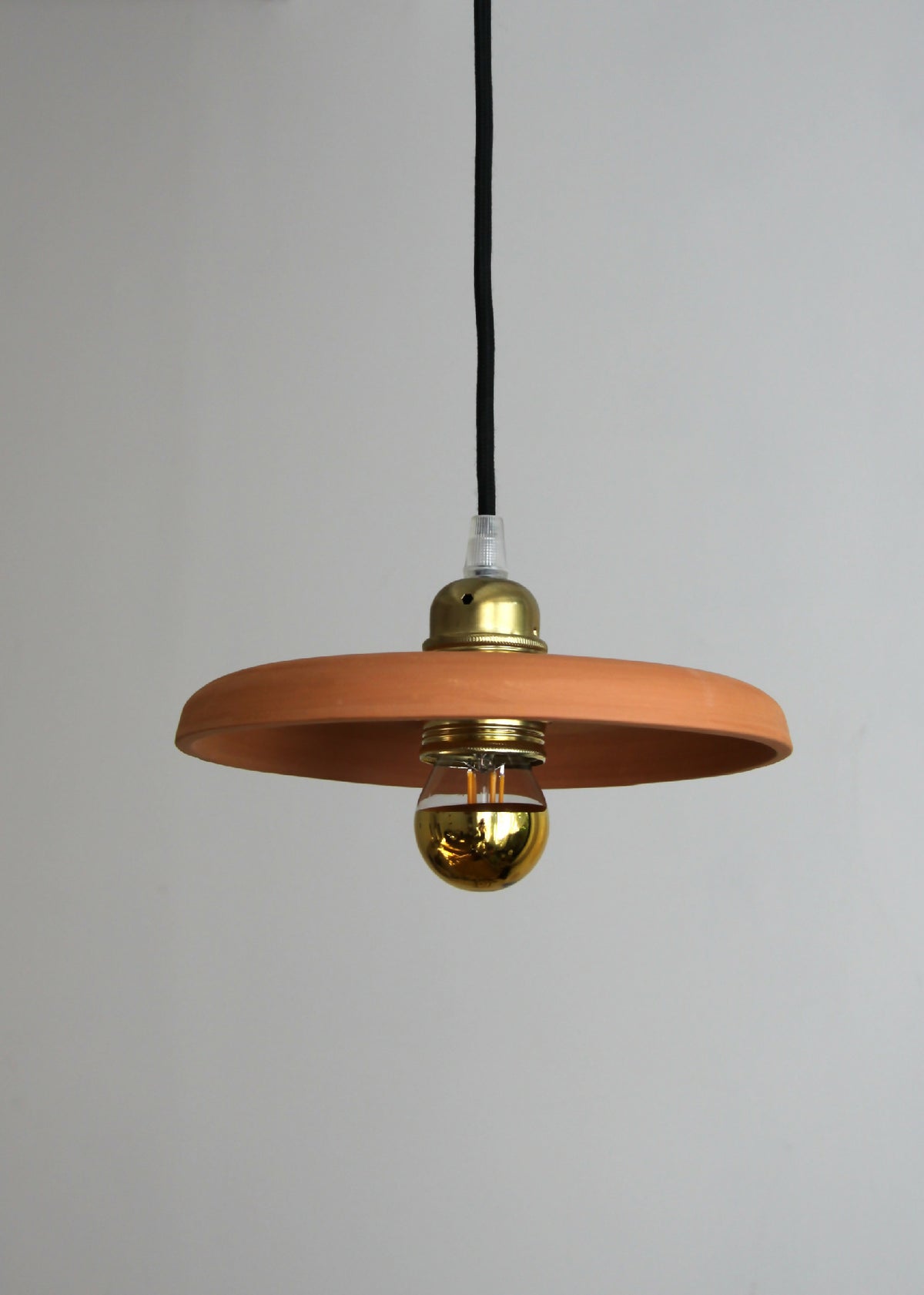 Suspension terracotta avec abat-jour circulaire et diffuseur doré sur cordon noir