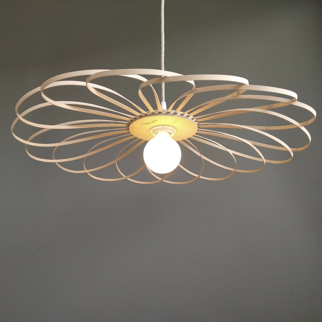 Suspension fleur 55 cm : motif ajouré en métal beige et ampoule blanche au centre.