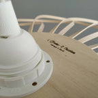 Base de suspension en plastique blanc avec marquage sur support en bois clair.