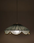 Suspension avec abat-jour sombre, bordure dorée ondulée et lumière allumée
