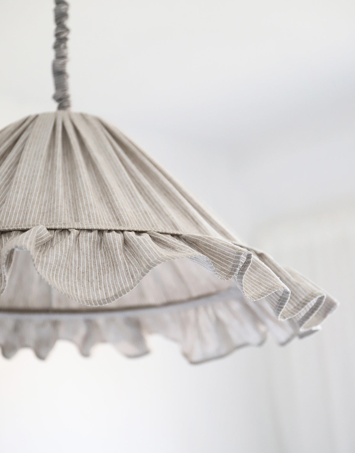 Suspension Emilia en tissu à fines rayures olive et blanches, volant plissé main, fabriquée en France par Hautlalampe