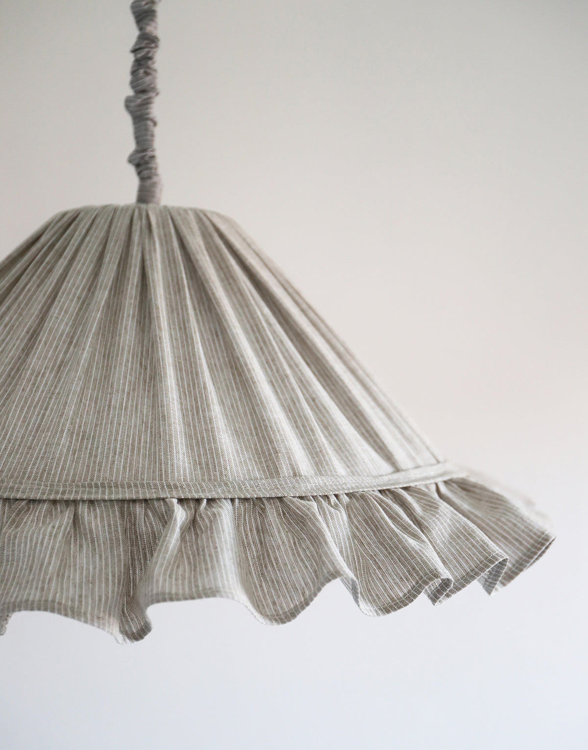 Suspension Emilia en tissu à fines rayures olive et blanches, volant plissé main, fabriquée en France par Hautlalampe