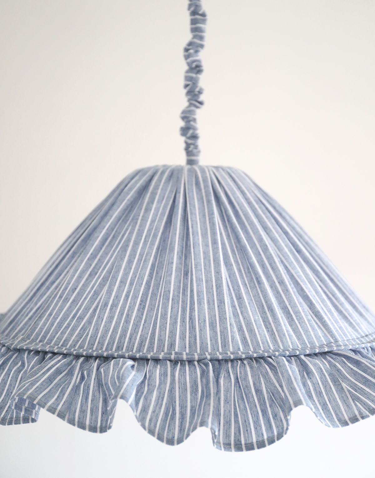 Suspension Emilia en tissu rayé bleu et blanc à volant plissé main, fabriquée en France par Hautlalampe