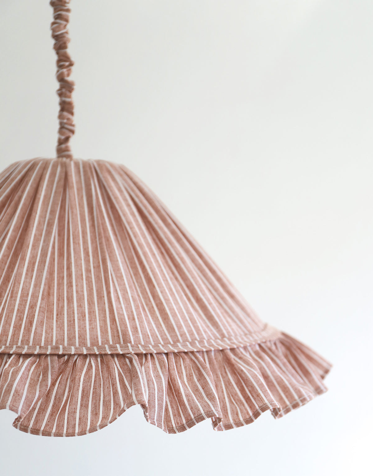 Suspension Emilia en tissu rayé terracotta et blanc à volant plissé main, fabriquée en France par Hautlalampe