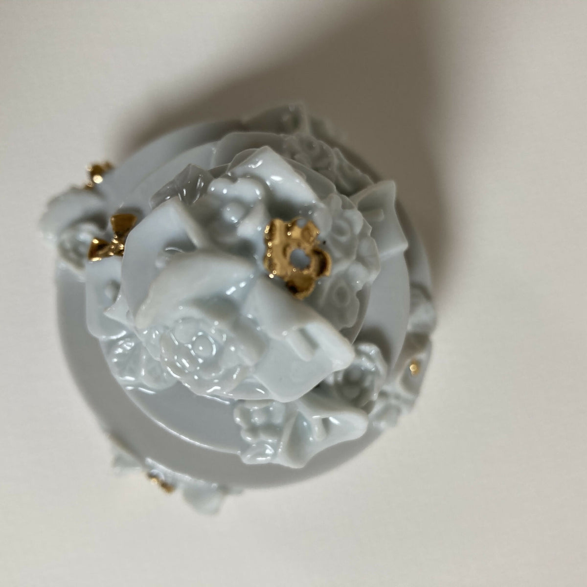 Boîte en porcelaine blanche, intérieur avec fleurs en relief et touches dorées.