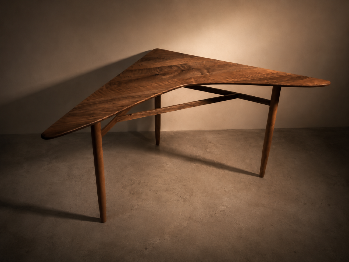 Table d’angle en bois brun, plateau trapézoïdal, pieds fuselés.