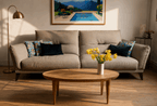 Table basse ronde en bois clair, pieds fins, plateau avec veines apparentes.