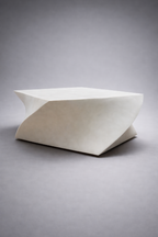 Table basse blanche aux lignes organiques, plateau rectangulaire incliné, vue trois-quarts.