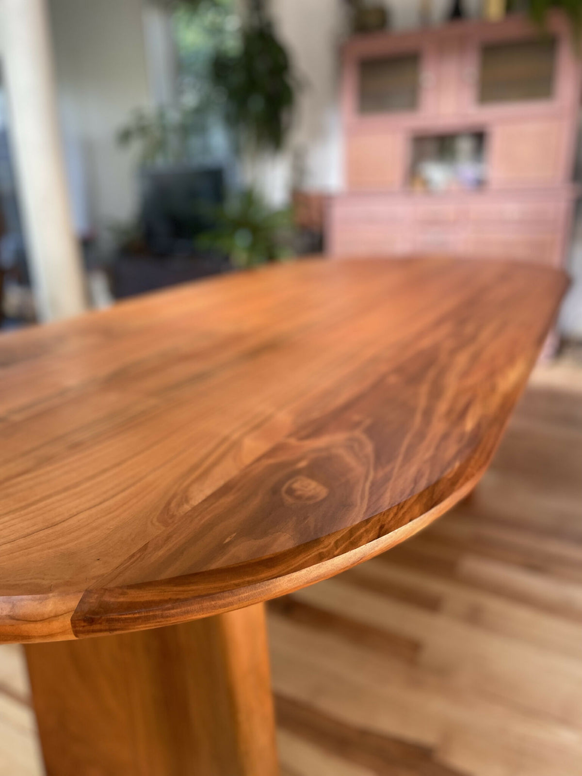 Plateau de table en bois avec veinures visibles et bord arrondi, vue rapprochée