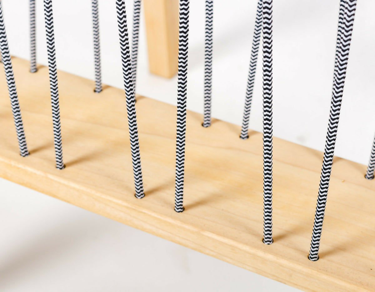 Bord de plateau en bois avec cordes noires verticales suspendues