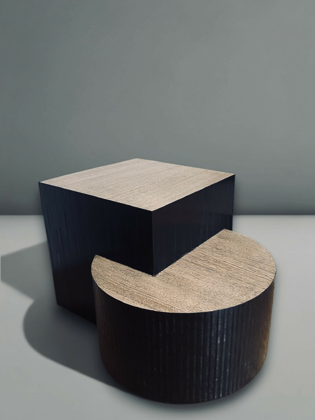 Table basse avec bloc carré en bois sombre et plateau cylindrique clair