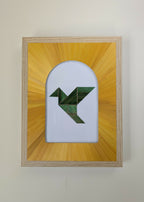 Tableau encadré en bois clair, motif géométrique vert sur fond blanc et jaune