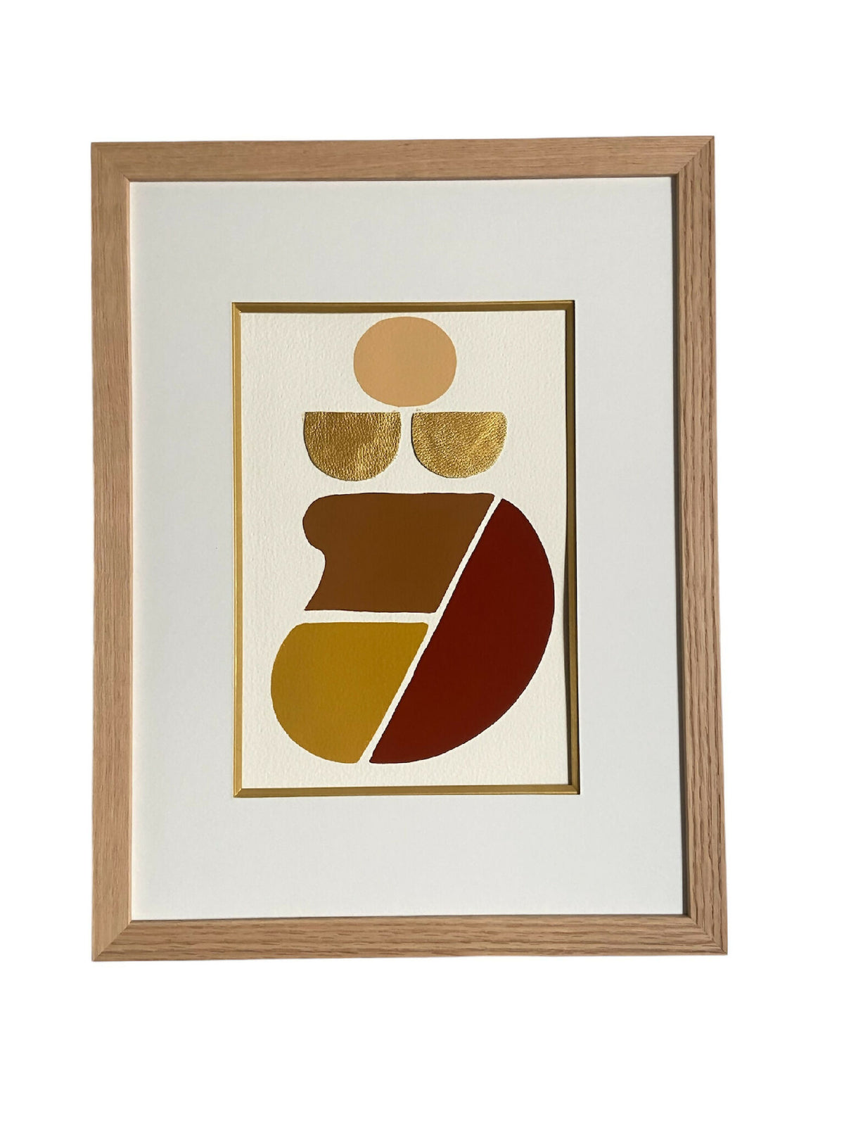 Tableau abstrait encadré, motifs géométriques dorés et rouges dans cadre en bois clair.