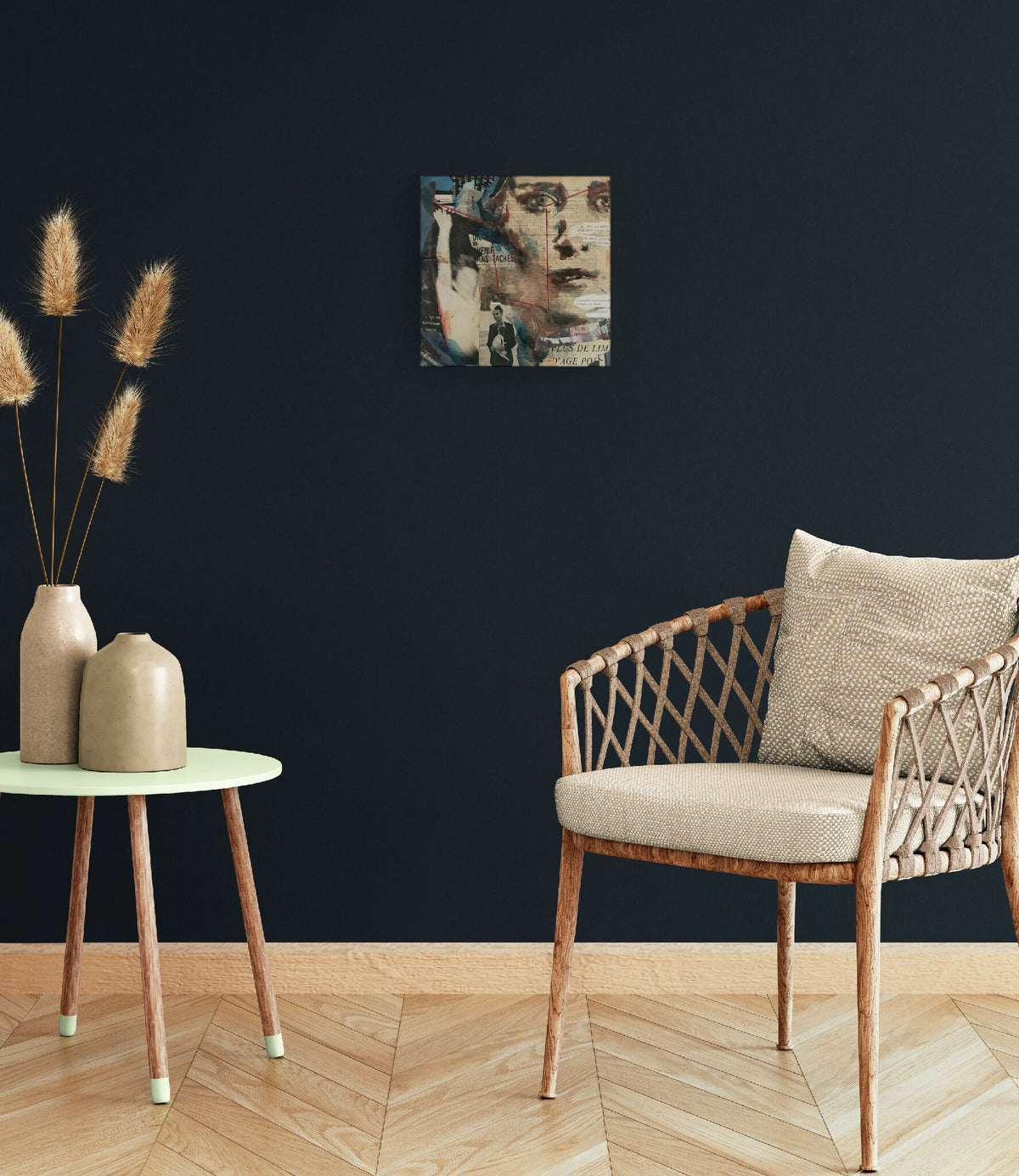 Petit tableau carré sur mur bleu, collage abstrait de photos et typographies.