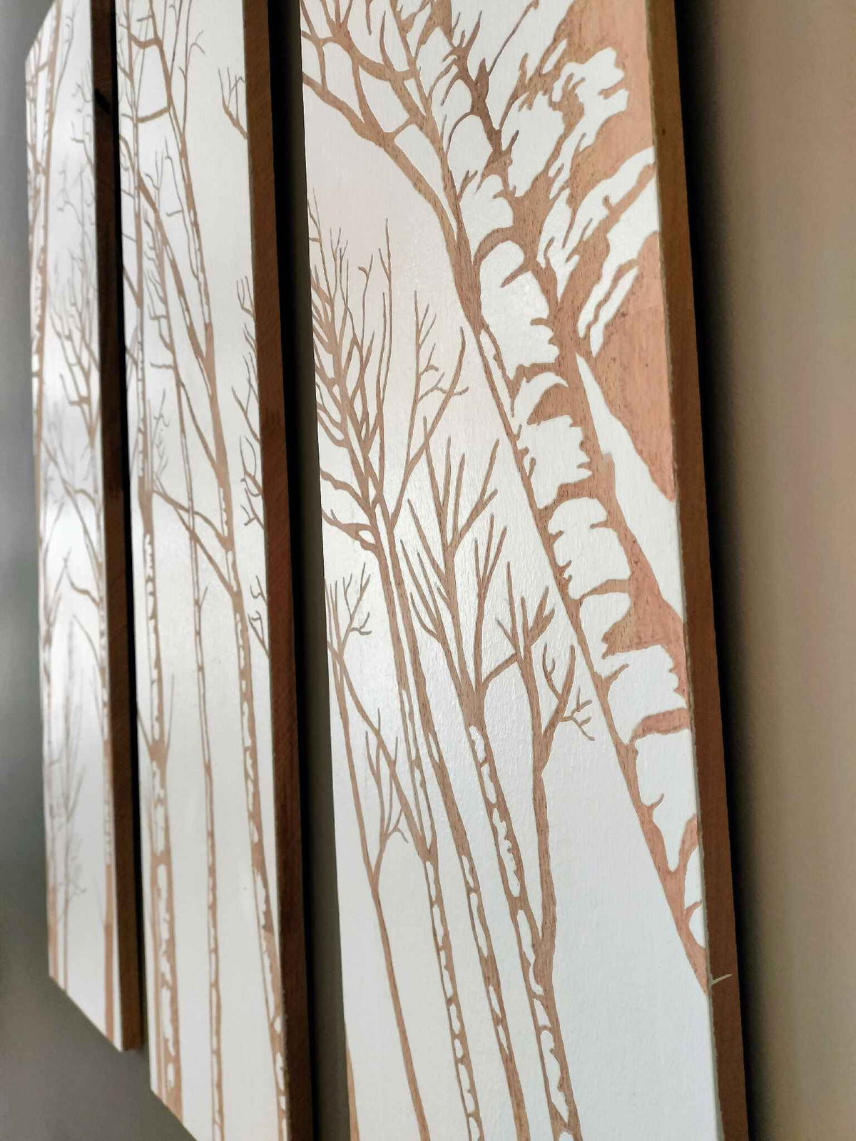 Triptyque mural : panneau vertical avec branches et silhouettes d’arbres beige sur fond clair