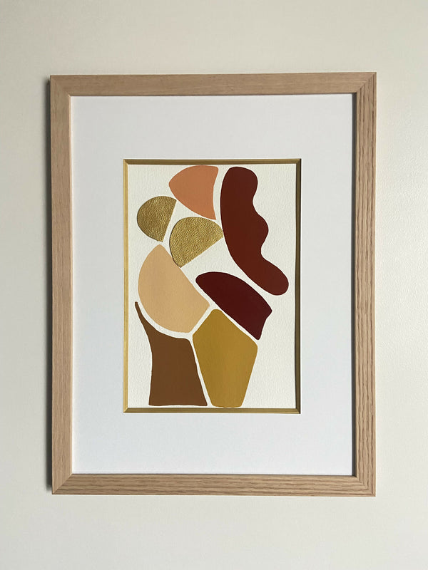 Tableau encadré d’art abstrait, silhouettes stylisées brunes et dorées sur fond clair.