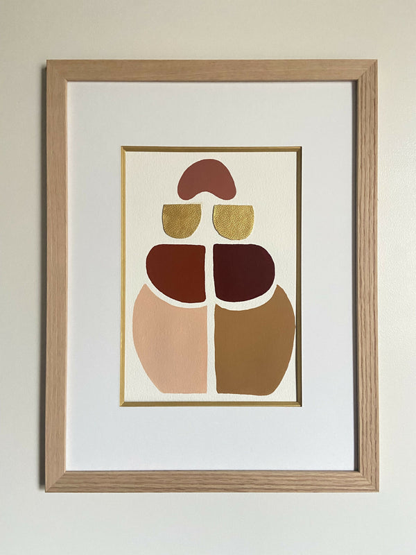 Tableau abstrait encadré en bois, formes géométriques aux tons rouges, beiges et or.