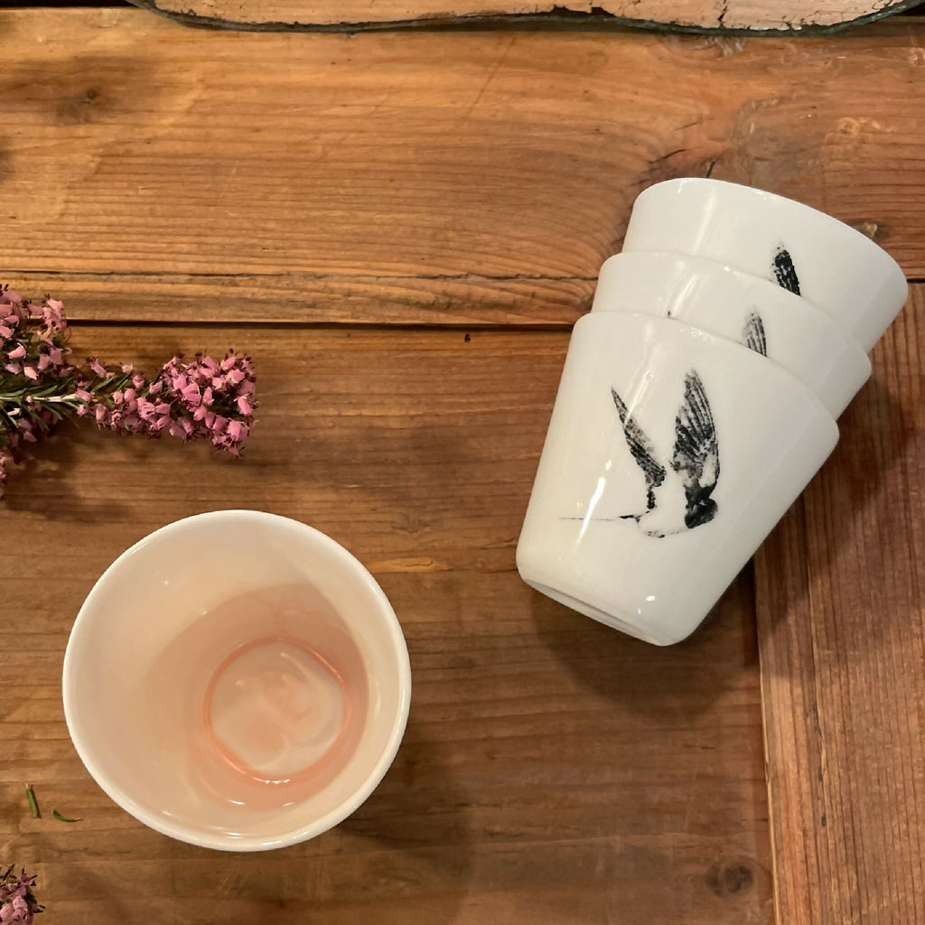 Tasse à ristretto blanche en céramique avec motif d’oiseau noir, vue de dessus partielle